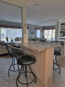 a kitchen with a large island with black chairs at Seascape in Haven Beach
