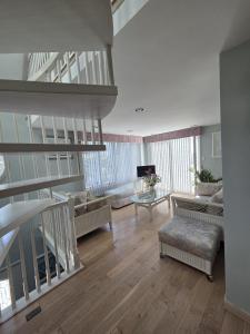 a living room with a staircase and a living room with a couch at Seascape in Haven Beach