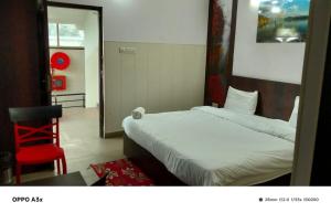 a hotel room with a bed and a red chair at hotel tamanna in Lucknow