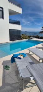 a swimming pool with a bench next to a building at Dinary Deluxe Apartments in Vir