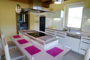 uma cozinha com balcões rosa e branco e um lavatório em Drevenica Nela em Zuberec