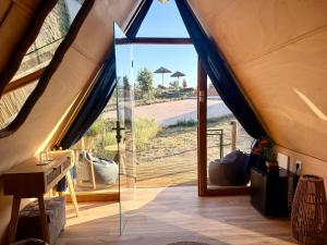 a room with a large glass door in a tent at Mama Adama, Alpaca Farm And B&B in Grândola +38 photos