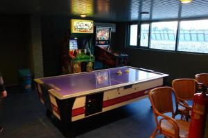 a ping pong table in a room with a video game at EuroParcs Schoneveld in Breskens