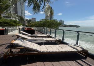a row of chaise lounges on a pier near the ocean at Hompton Hotel by the Beach in George Town +46 photos