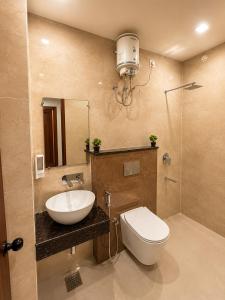a bathroom with a sink and a toilet and a mirror at Hotel Ram Sadan in Ayodhya