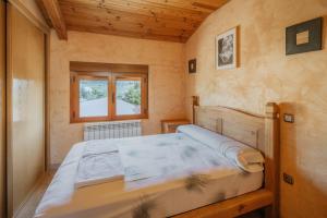 a bedroom with a bed in a room with a window at Peña in Castro de Fuentidueña