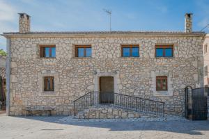 a stone building with a staircase in front of it at Peña in Castro de Fuentidueña