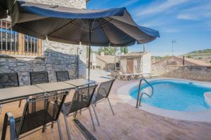 a patio with an umbrella and a swimming pool at Peña in Castro de Fuentidueña
