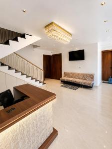 a lobby with stairs and a couch and a television at Hotel Ram Sadan in Ayodhya