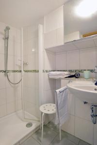a white bathroom with a shower and a sink at Ferienwohnungen by Weingut Hommes in Ernst Mosel in Ernst +42 photos