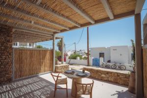 a patio with a table and chairs on a stone wall at 5 Elements - Agapi's Houses in Antiparos