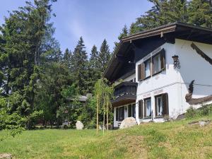 a large white house on a hill with trees at Chalet Glauninger in Ramsau am Dachstein
