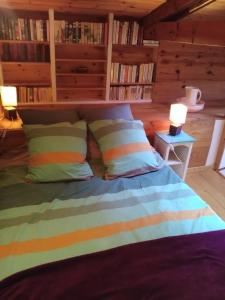 a bedroom with a bed with pillows and a book shelf at Les chambres de Kerael in Crozon
