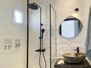 a bathroom with a shower with a sink and a mirror at CHARMA Mykonos in Kalo Livadi