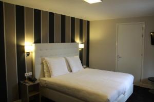 a bedroom with a bed with a striped wall at Fletcher Hotel-Restaurant Duinzicht in Ouddorp
