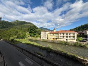 a building next to a river next to a road at Entre Rivière et Sommets in Seix