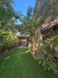 a yard with green grass and a bridge at Amaroo - Bring your own linen in Arakoon