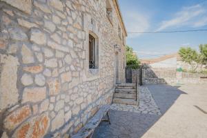 a stone building with a window and stairs on it at Sanz in Castro de Fuentidueña