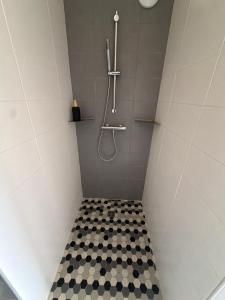 a bathroom with a shower with a black and white tiled floor at Entre Rivière et Sommets in Seix +19 photos