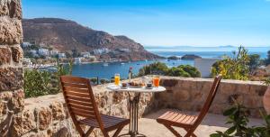 a table and chairs on a balcony with a view of the ocean at Theologos Houses in Grikos