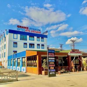 a large building with a sign in front of it at Mavi OTEL BOUTİQUE RESTAURANT in Mahmutlu