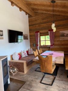 a living room with a couch and a table at Almhütte Eibingalm in Saalbach-Hinterglemm