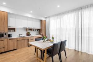 a kitchen with a table and chairs in a kitchen at Kove Apartment - G06 in Kiama