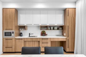 a kitchen with white cabinets and a sink at Kove Apartment - G06 in Kiama +2 photos