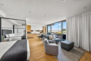 a bedroom with a bed and a living room at Kove Apartment - G06 in Kiama