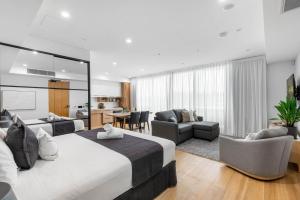 a bedroom with a large bed and a living room at Kove Apartment - G06 in Kiama