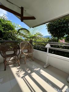 a balcony with two chairs and an umbrella at Hotel Pison in Rantepao