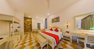 a bedroom with a bed and a desk in a room at Spree Resort Sariska in Thāna Ghāzi