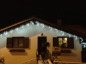 Una casa con luces de Navidad en un lado. en La posa sul lago, en Rimasco