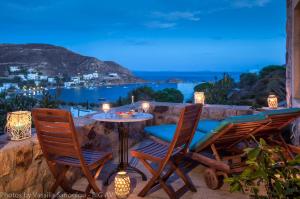 a patio with two chairs and a table with a view at Theologos Houses in Grikos