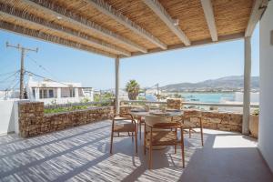 a patio with a table and chairs and a view of the ocean at 5 Elements - Agapi's Houses in Antiparos