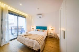 a bedroom with a large bed and a large window at Apartamentos Sibarys in Nerja