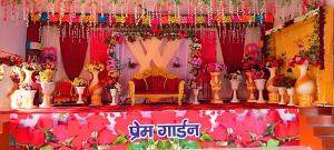 a room with a stage with flowers and a chair at Prem Garden in Bhiwāni