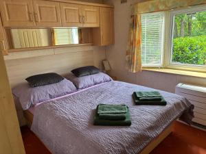 a bedroom with a bed with two green towels on it at Ubytování Levandule in Košín