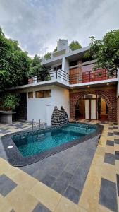 a house with a swimming pool in front of it at Mango Orchards Two in Auroville
