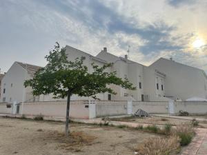 a tree in front of a white building at PLAYA ALMARDA CORINTO, PISCINA, WIFI,2 TERRAZAS, BARBACOA,TRANQUILo in Sagunto