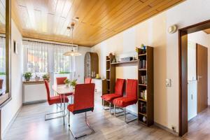 a dining room with red chairs and a table at Gierske Ferienwohnung in Olsberg