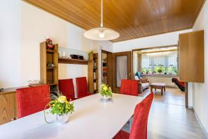 a dining room with a white table and red chairs at Gierske Ferienwohnung in Olsberg +17 photos
