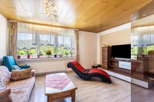 a living room with a couch and a tv at Gierske Ferienwohnung in Olsberg