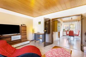 a living room with a flat screen tv and a desk at Gierske Ferienwohnung in Olsberg