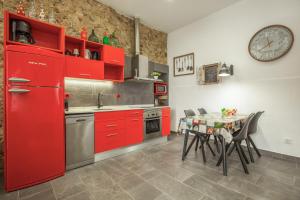a kitchen with red cabinets and a table with chairs at Petit Loft in Canet de Mar