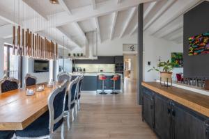 a kitchen and dining room with a wooden table and chairs at Villa de Lujo Cerca de Sitges in Sant Pere de Ribes