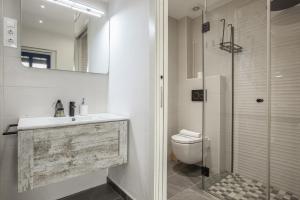 a bathroom with a toilet and a glass shower at Petit Loft in Canet de Mar +17 photos