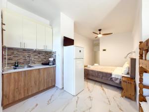 a kitchen with a white refrigerator and a bed at Villa Kalliopi in Gerakini +53 photos
