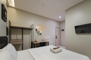 a bedroom with a white bed and a desk at Cove Juanda One in Jakarta