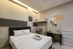 a bedroom with a white bed and a desk at Cove Juanda One in Jakarta